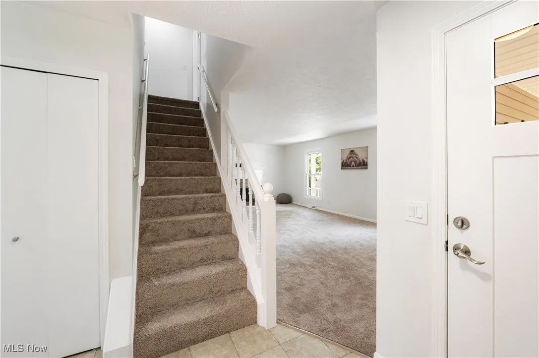 Stairs with carpet floors and tile patterned flooring