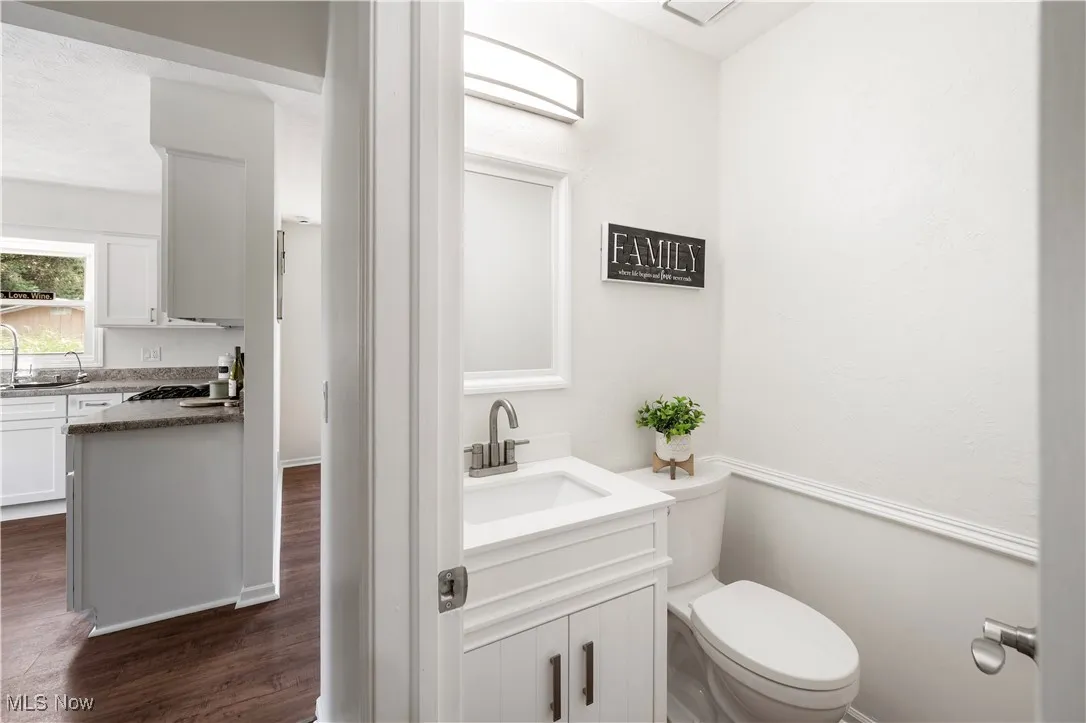 Half bath with vanity and wood finished floors
