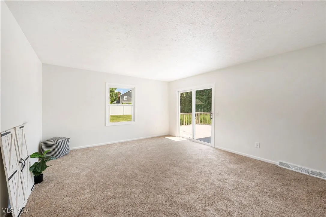 Unfurnished room with carpet flooring and a textured ceiling