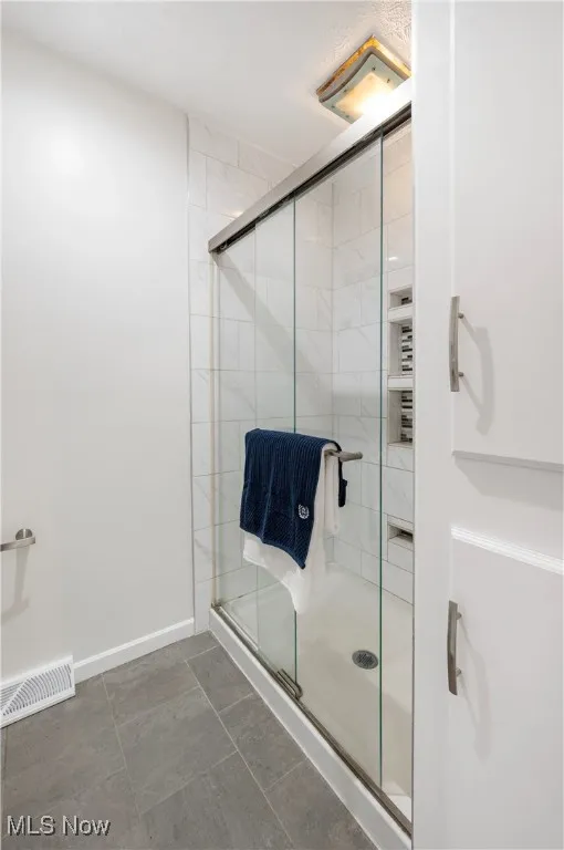 Bathroom with a stall shower and baseboards