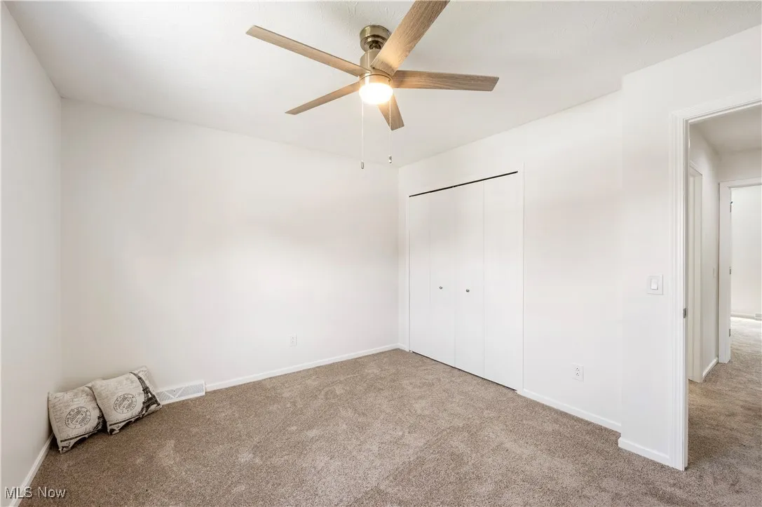 Unfurnished bedroom with carpet flooring, a closet, and ceiling fan