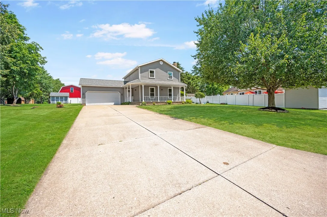 Traditional-style house featuring a porch, driveway, and an attached garage