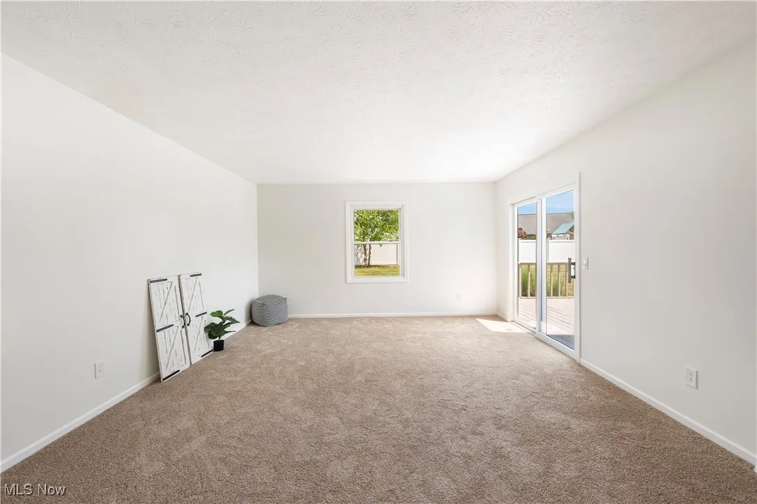 Unfurnished room featuring carpet flooring and a textured ceiling