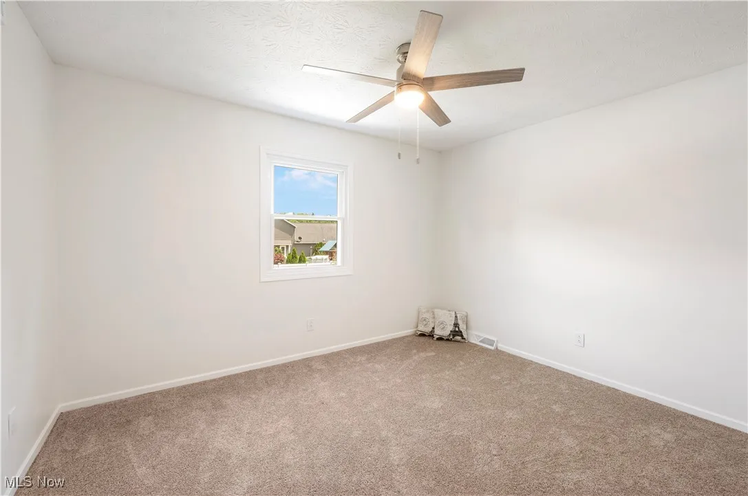 Unfurnished room with carpet and a ceiling fan