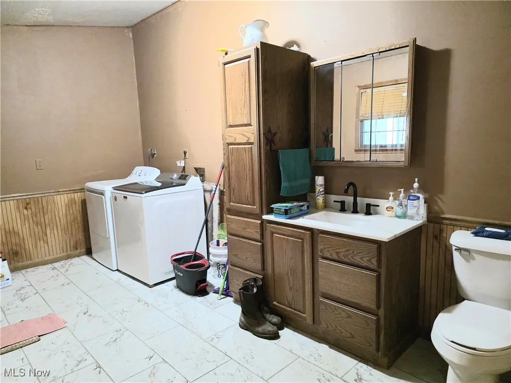 Laundry room with washing machine and dryer, light marbled tile floors
