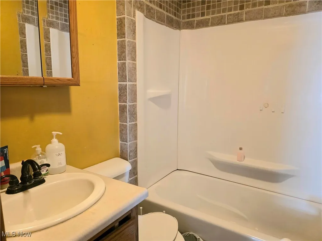 Full bath with vanity and shower / tub combination