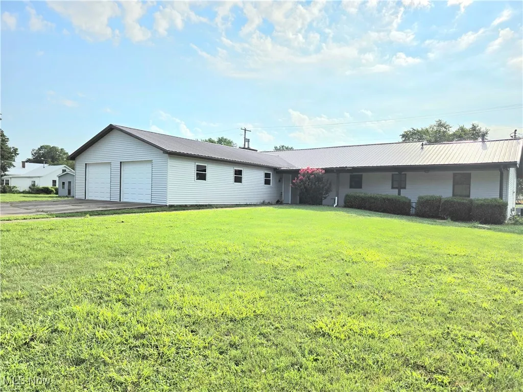 View of rear attached garage and yard