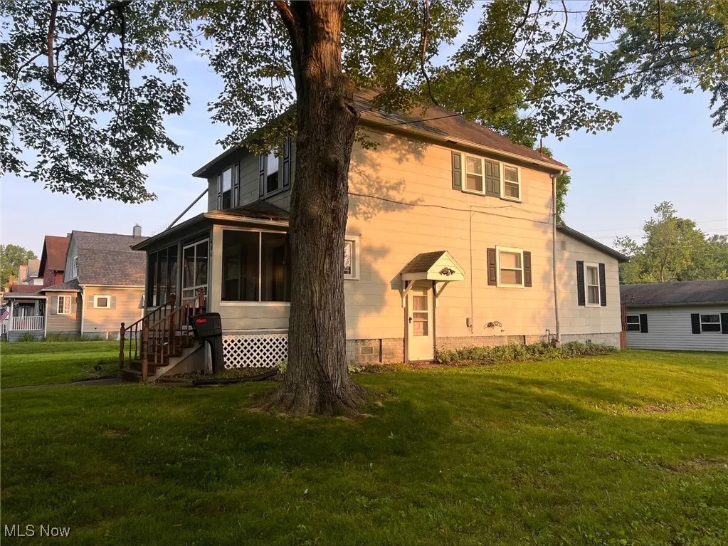 Back of house featuring a sunroom and a lawn