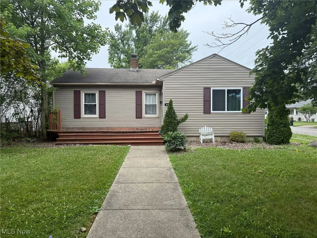 View of front of home with a chimney and a front yard