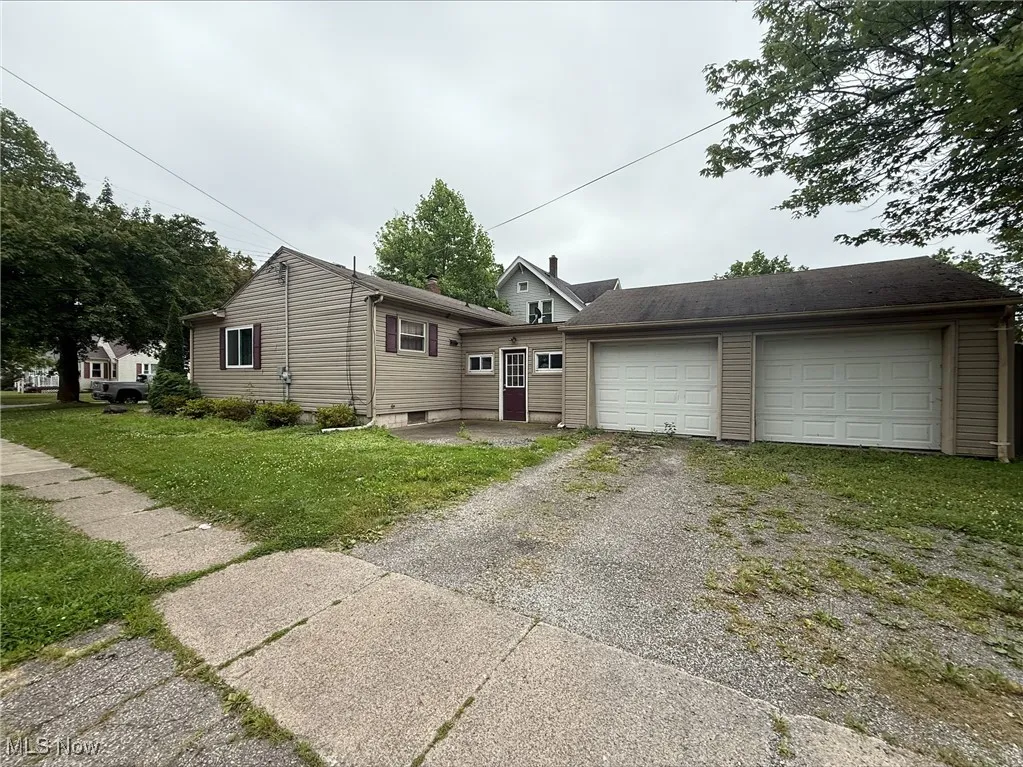 View of front of home featuring driveway and a front lawn