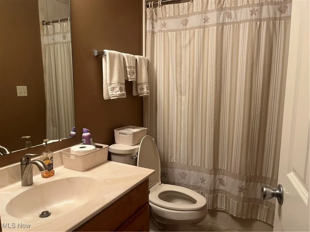 Full bath featuring vanity, tile patterned flooring, and curtained shower