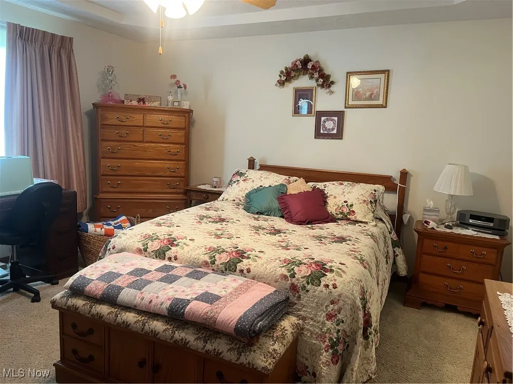 Bedroom featuring light carpet and multiple windows