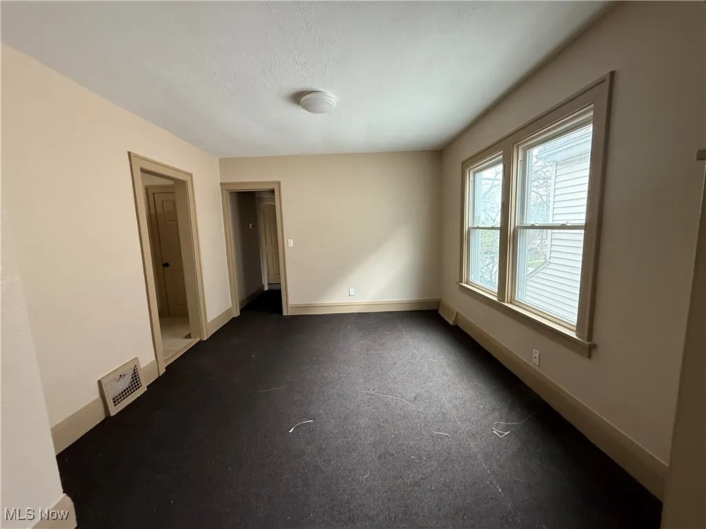 Unfurnished room with baseboards and a textured ceiling