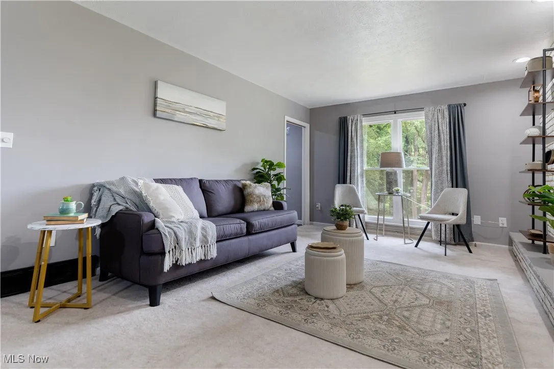Carpeted living room featuring baseboards