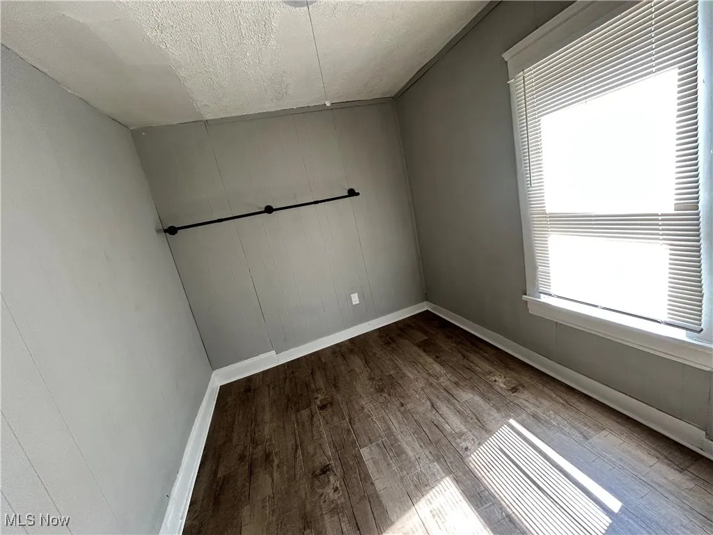 Empty room featuring wood finished floors and a textured ceiling