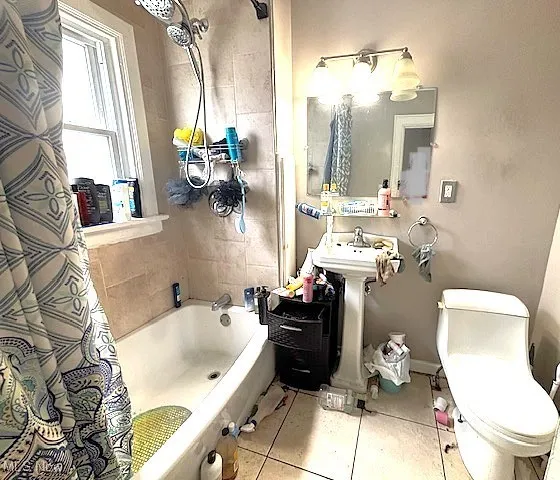 Bathroom featuring shower / tub combo with curtain and tile patterned floors