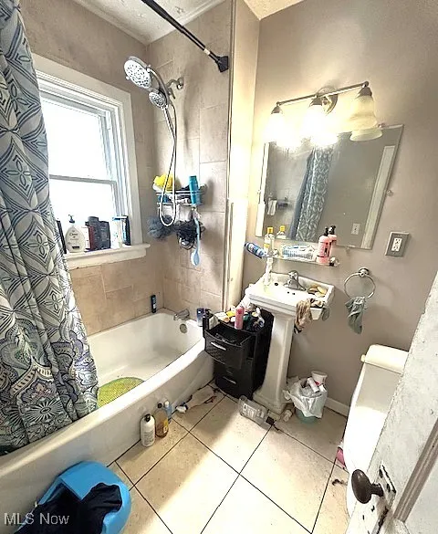 Bathroom featuring shower / bath combination with curtain and tile patterned flooring