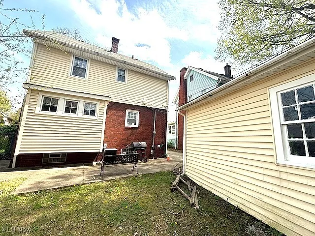 Back of property featuring a chimney and a patio