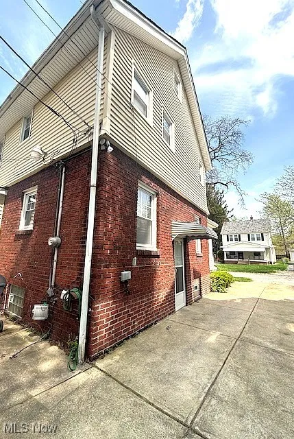 View of side of home with brick siding and driveway