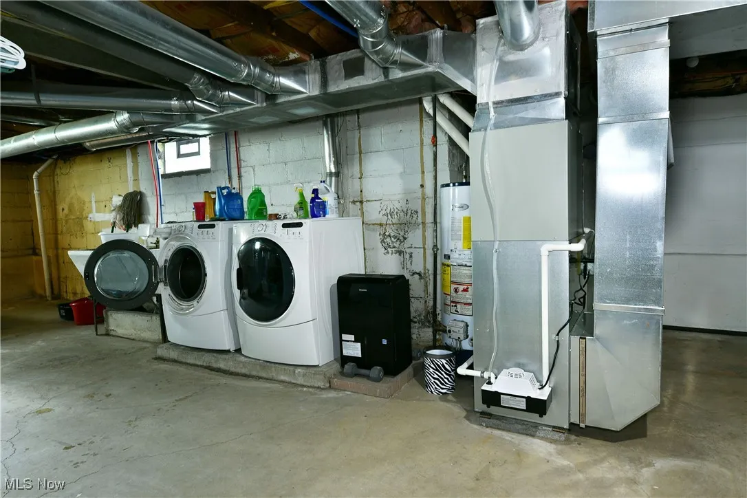 Below grade area with washing machine and clothes dryer, heating unit, and water heater