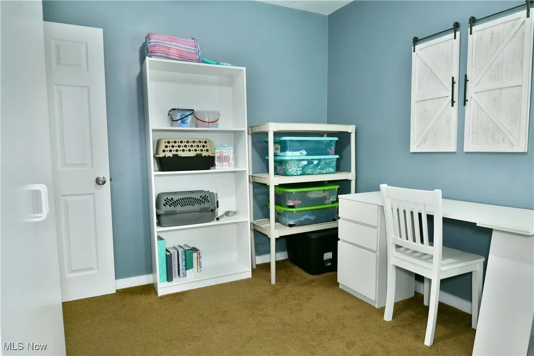 Bedroom featuring carpet and baseboards