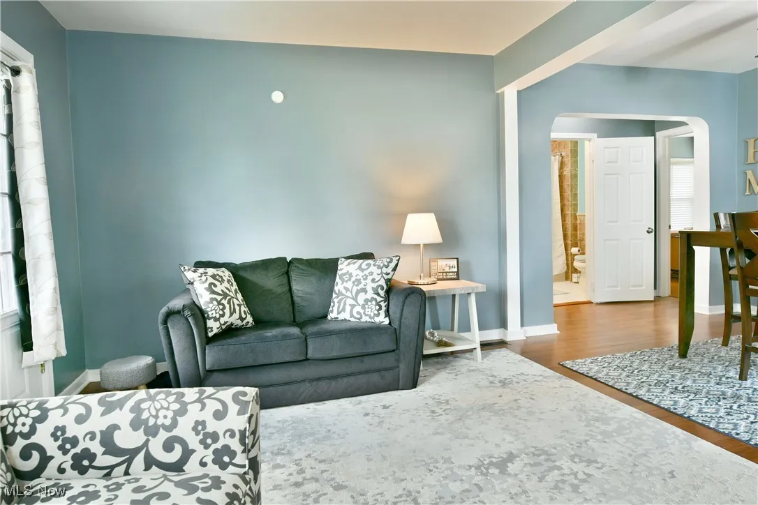 Living area with arched walkways and wood finished floors