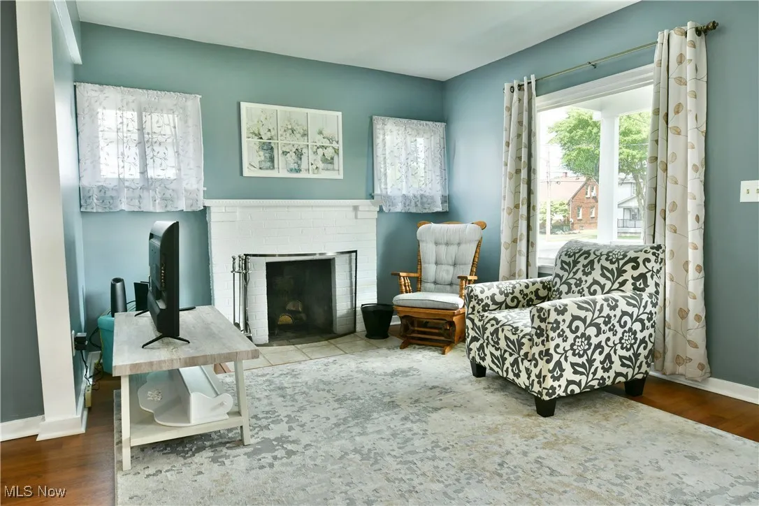Living area featuring wood finished floors and a brick fireplace