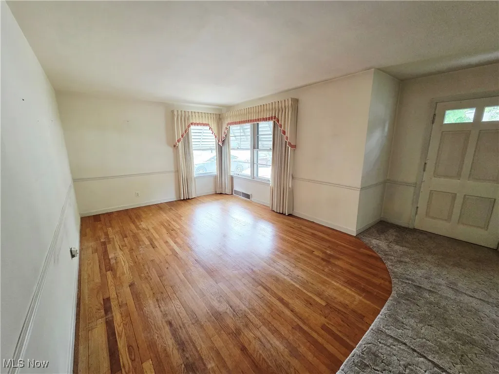 Spare room featuring light wood-type flooring and baseboards