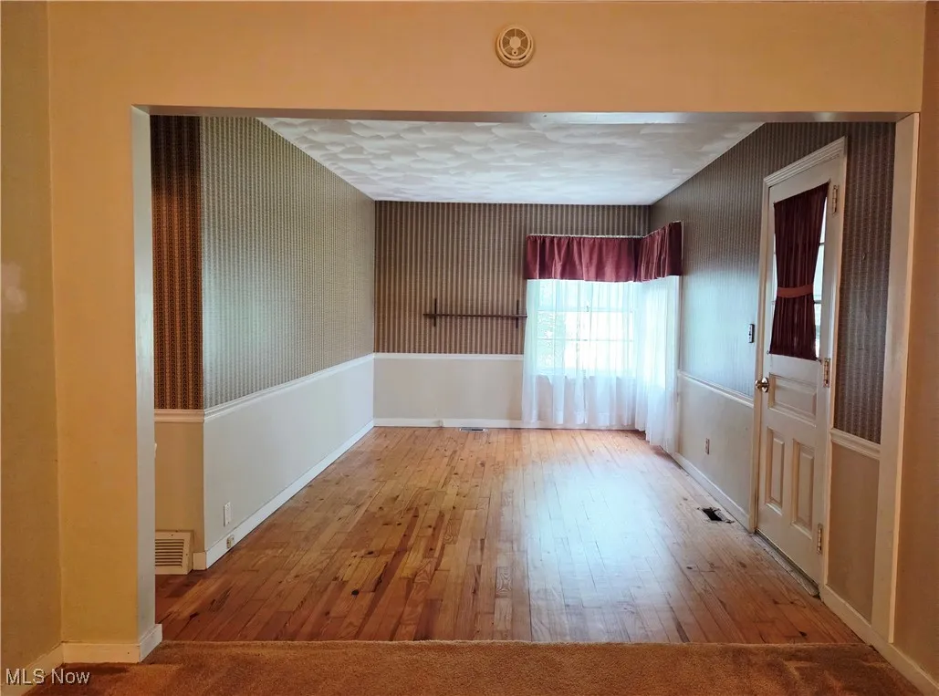 Spare room with hardwood / wood-style floors and baseboards