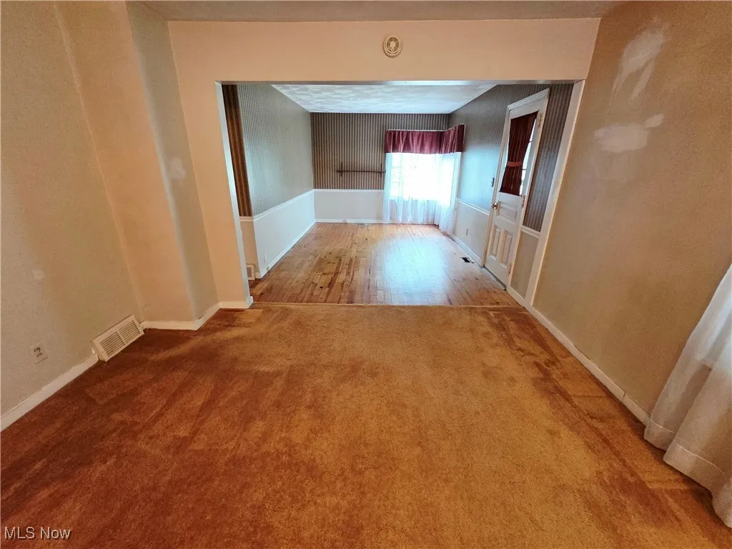 Hall featuring carpet and baseboards
