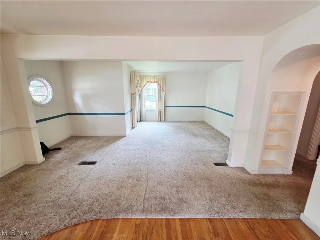Empty room featuring carpet floors and wood finished floors