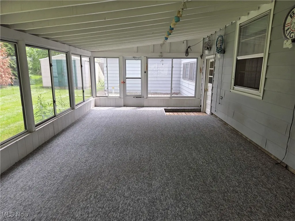 Unfurnished sunroom with lofted ceiling