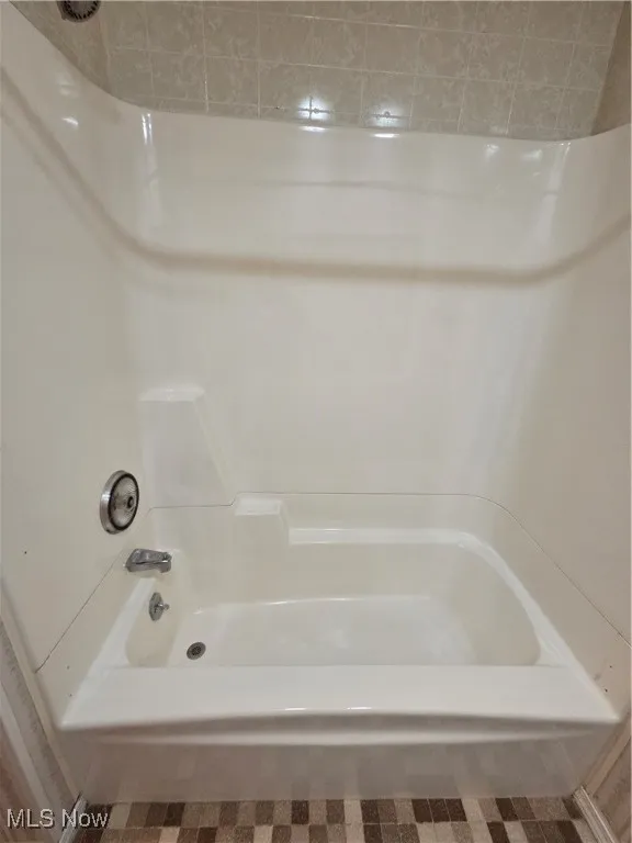 Full bathroom featuring shower / bath combination and tile patterned floors