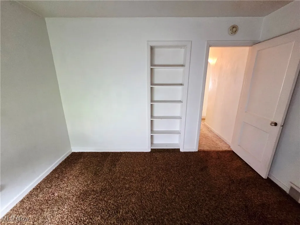 Unfurnished bedroom featuring baseboards and carpet flooring