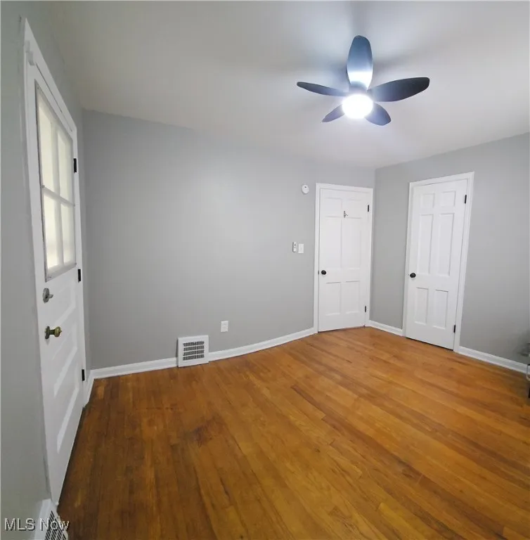Empty room featuring a ceiling fan and wood finished floors