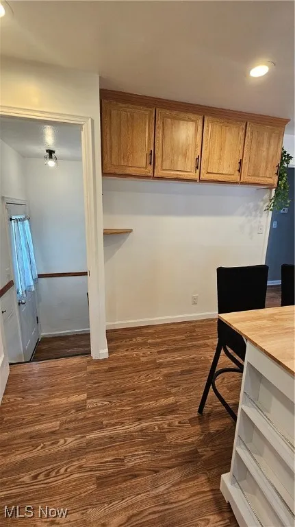 Kitchen with recessed lighting, dark wood-type flooring, and brown cabinets