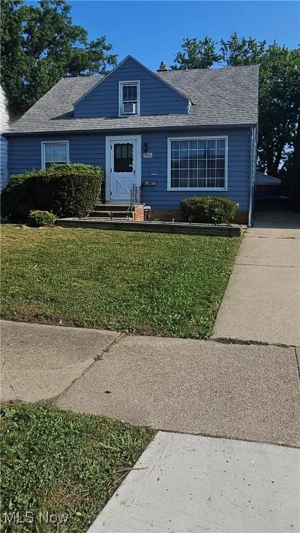 Bungalow-style home with a front yard and a shingled roof