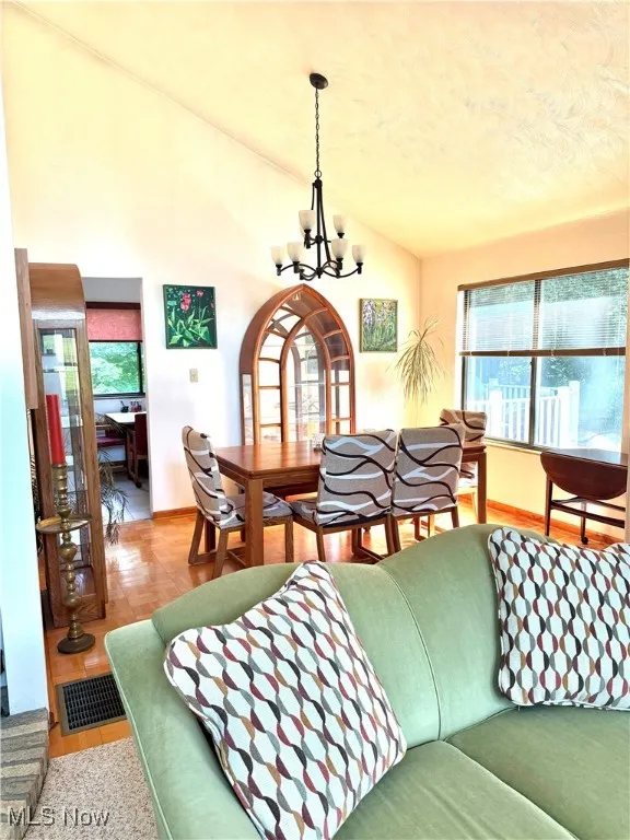 Dining room with a chandelier, vaulted ceiling, and healthy amount of natural light