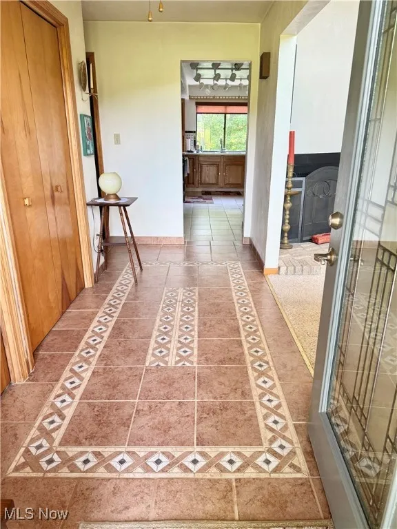 Hall featuring baseboards and inlaid floor details