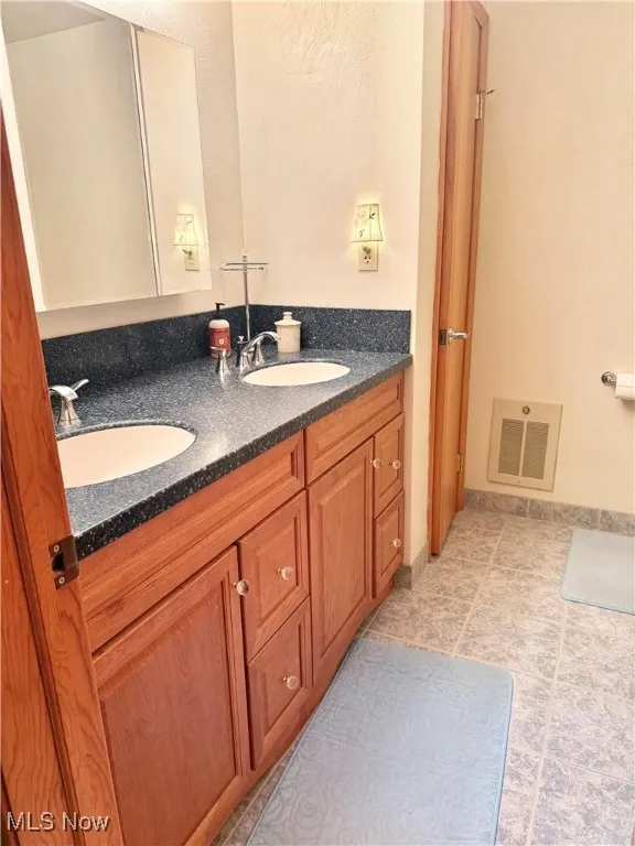 Bathroom featuring double vanity and tile patterned floors