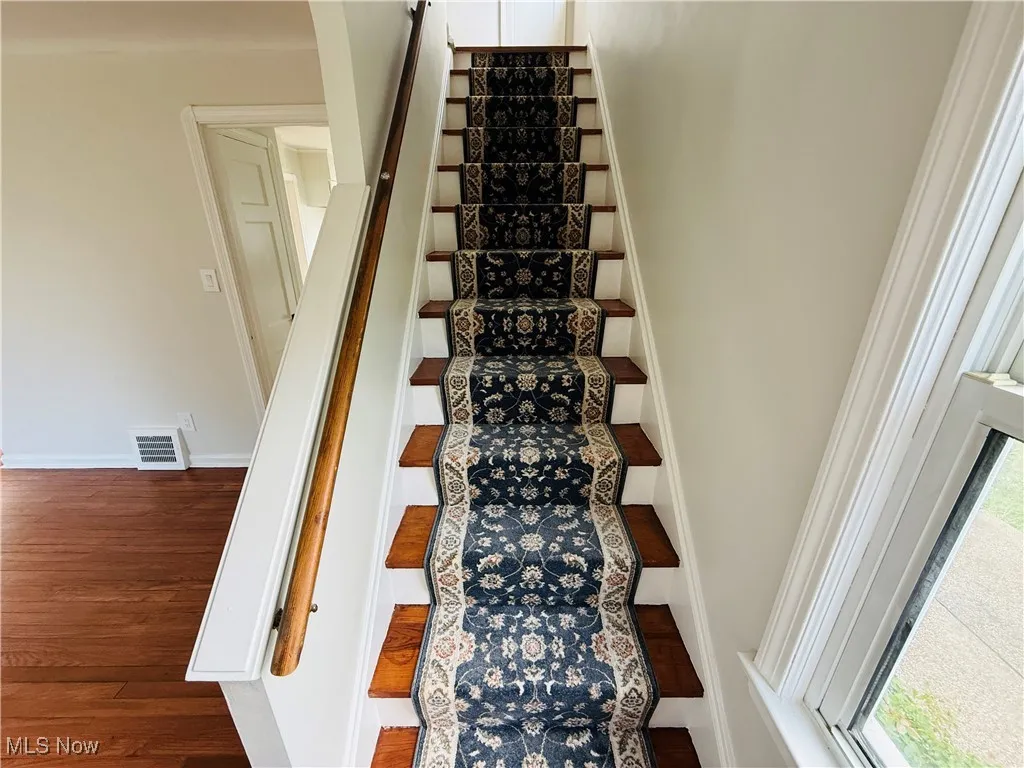 Stairs featuring wood finished floors and baseboards