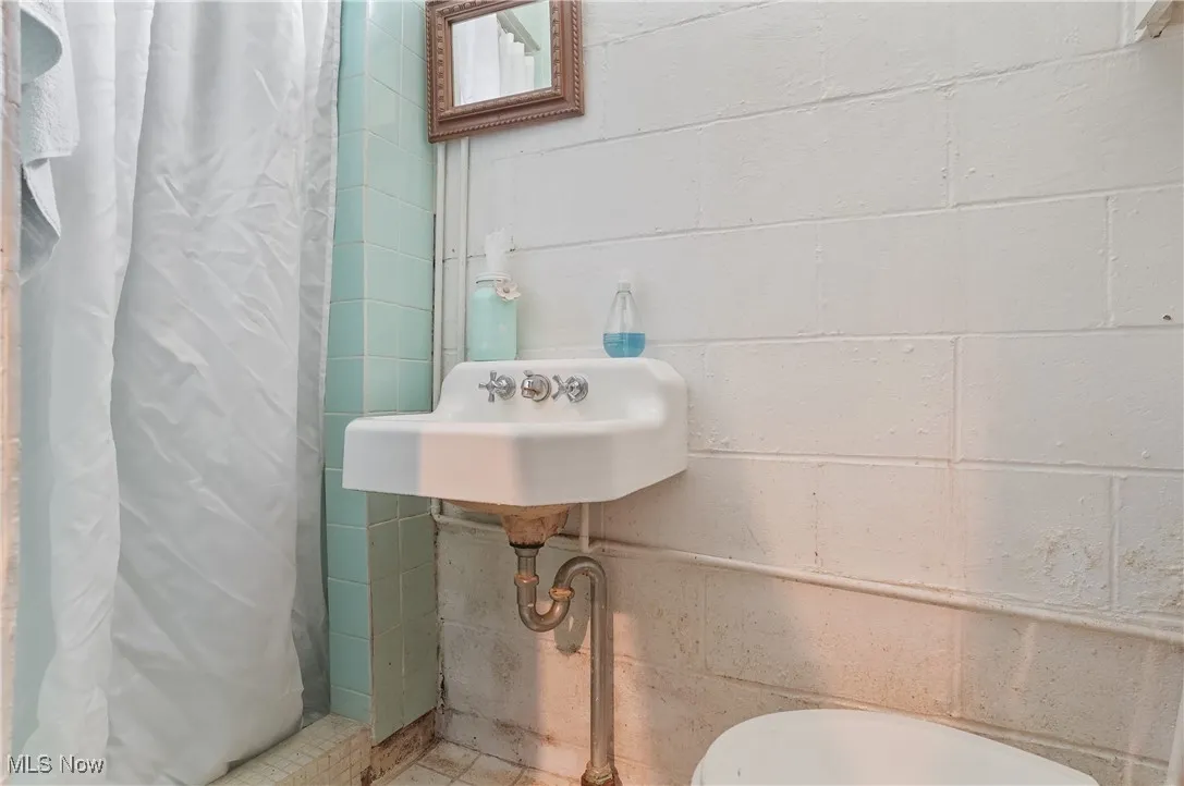 Bathroom with a shower with curtain and a sink