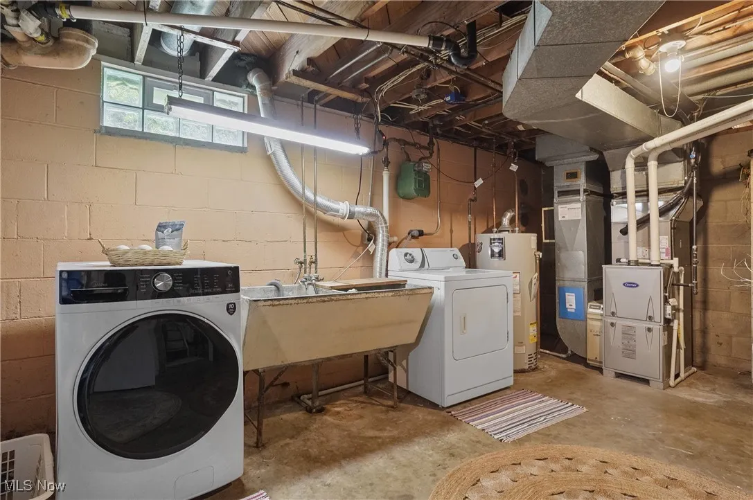 Laundry area featuring gas water heater, independent washer and dryer, and heating unit