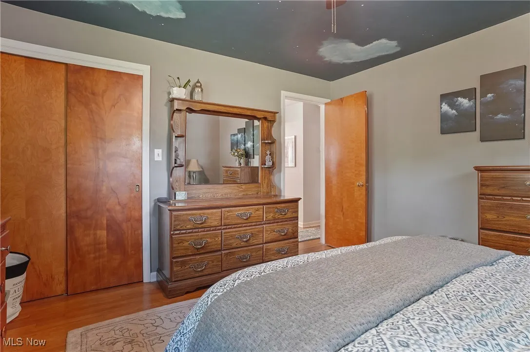Owners Bedroom with wood finished floors, a closet, and a ceiling fan
