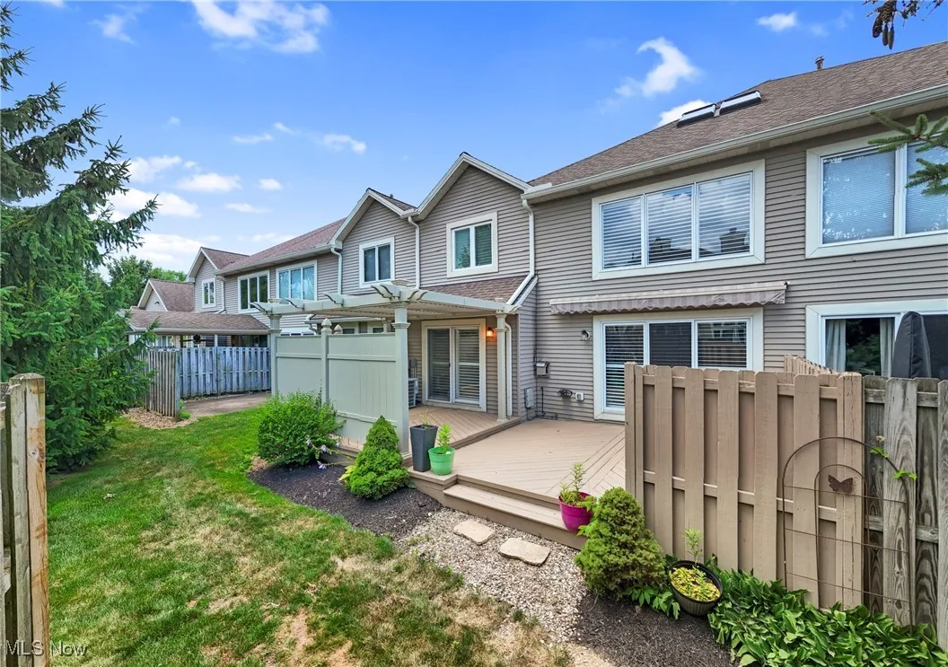 Back of property featuring a deck and a pergola
