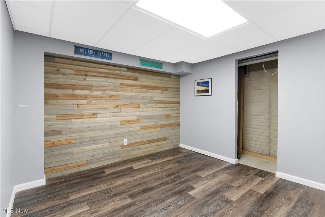 Unfurnished bedroom with a paneled ceiling and dark wood-style floors