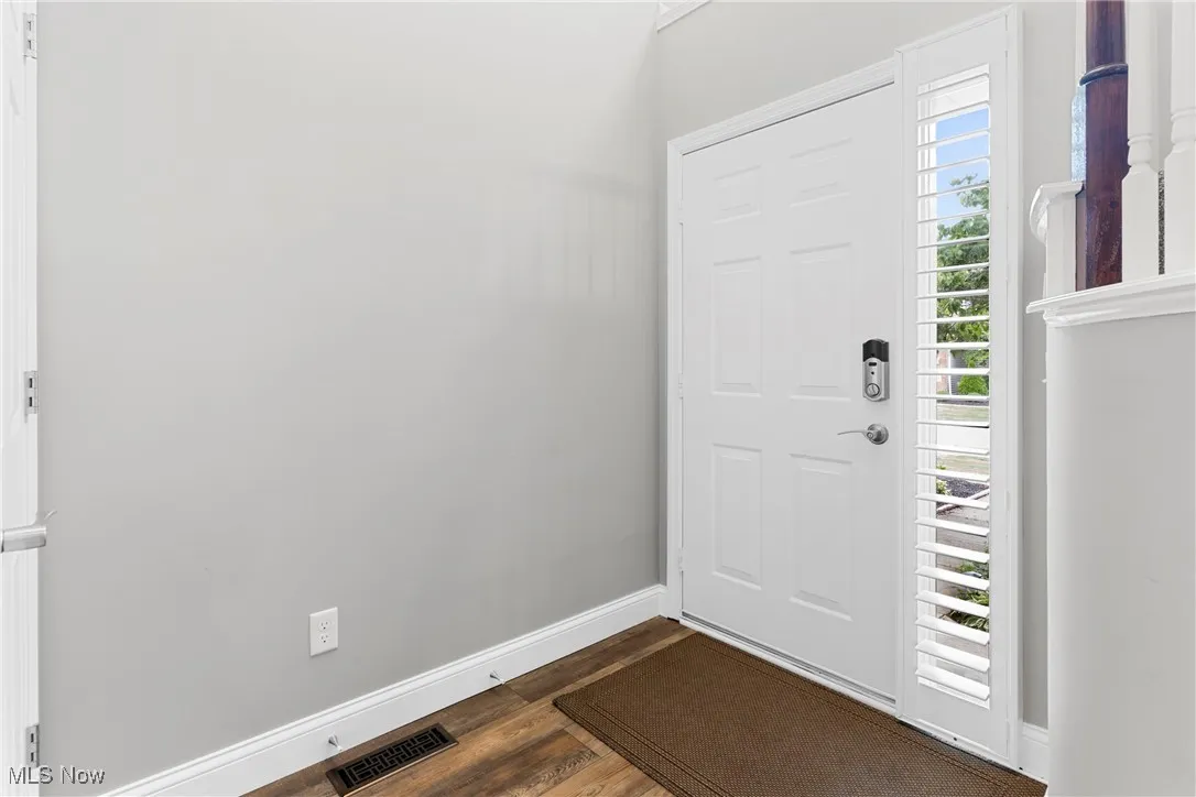 Entryway featuring dark wood-style flooring and baseboards