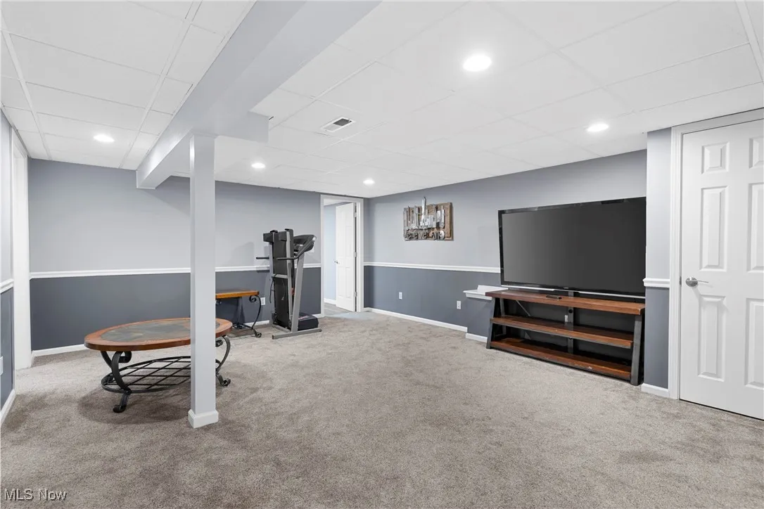 Workout area featuring carpet floors, a paneled ceiling, and recessed lighting