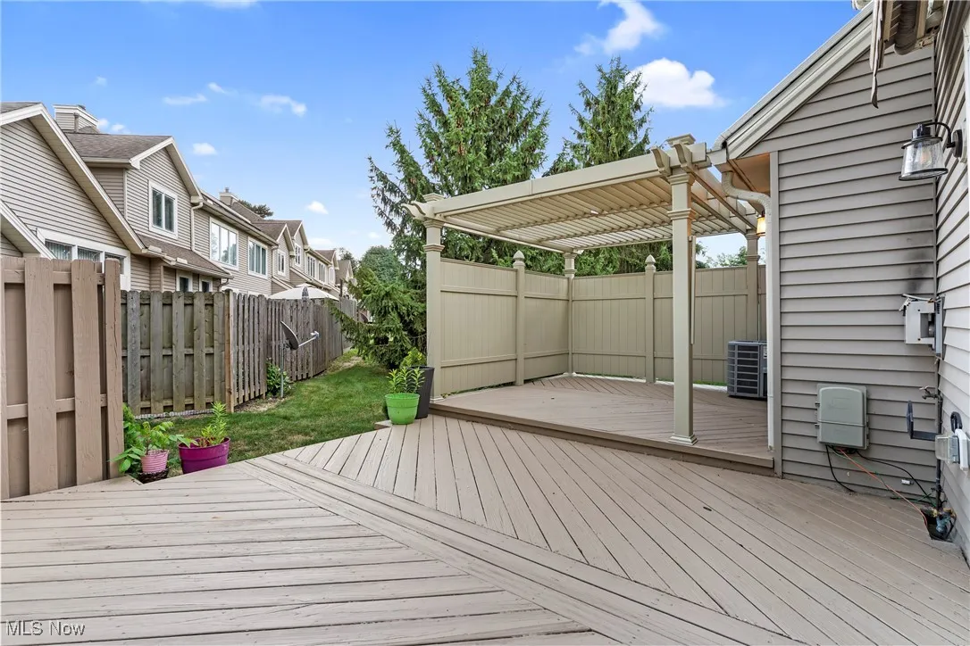 Deck with a pergola, a fenced backyard, and a residential view