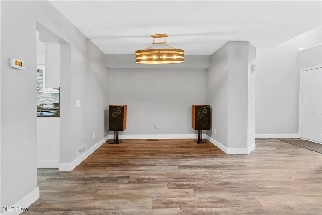 Unfurnished room with wood finished floors and baseboards